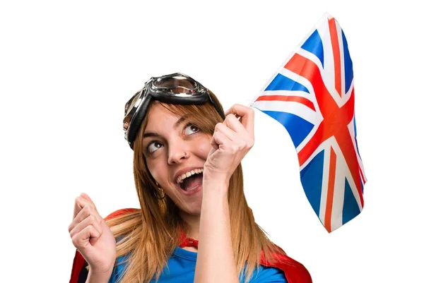 Pretty superhero girl holding an United Kingdom flag — Stock Photo, Image