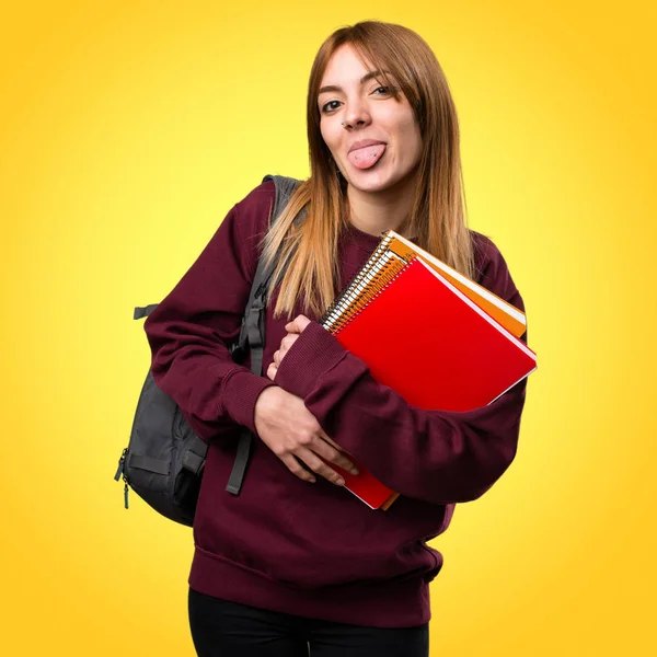 Renkli arka plan üzerinde dilini yaptırmayı öğrenci kadın