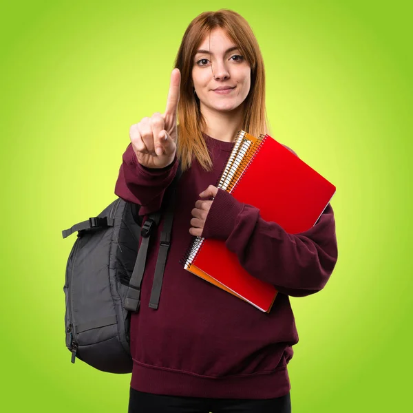 Étudiant femme compter un sur fond coloré — Photo