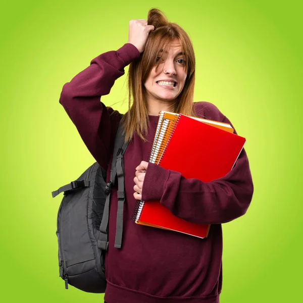 Mujer estudiante frustrado en fondo colorido — Foto de Stock