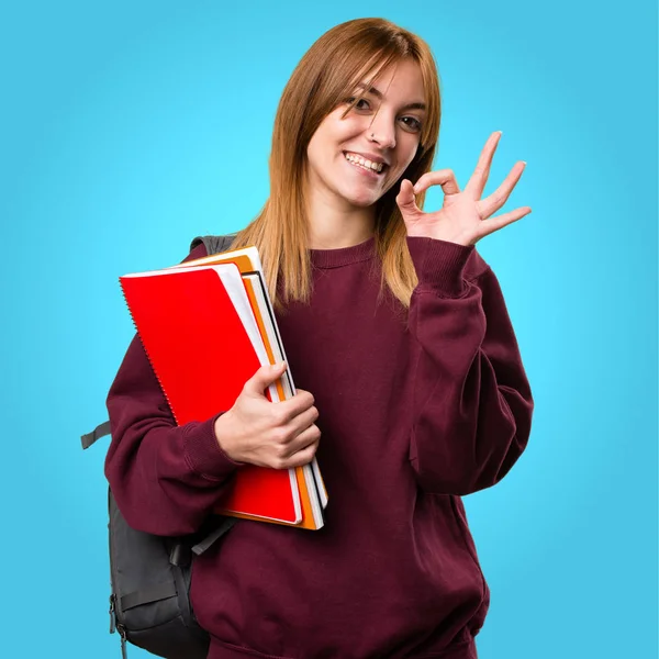 Öğrenci kadın Tamam renkli arka plan üzerinde kayıt yapma