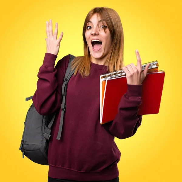 Öğrenci kadın yapma sürpriz jest renkli arka plan üzerinde