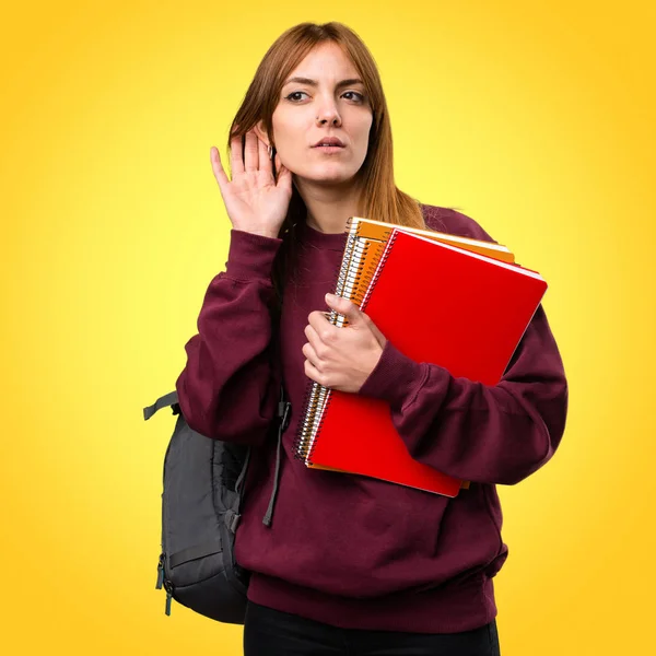 Renkli arka plan üzerinde bir şey dinlerken öğrenci kadın