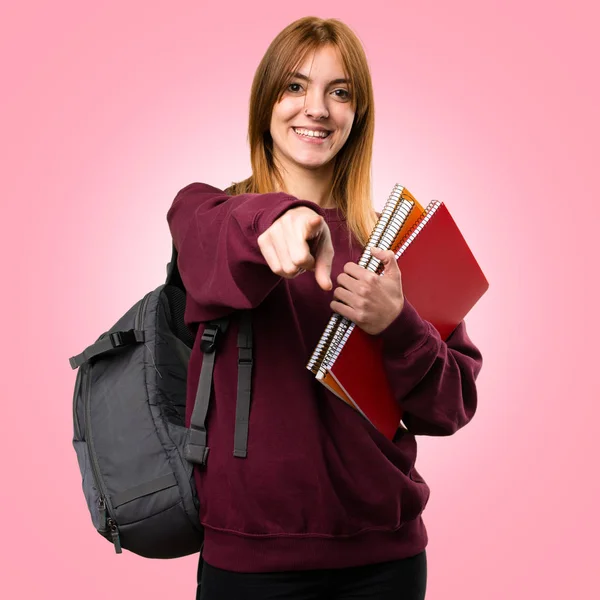 Estudante mulher apontando para a frente no fundo colorido — Fotografia de Stock