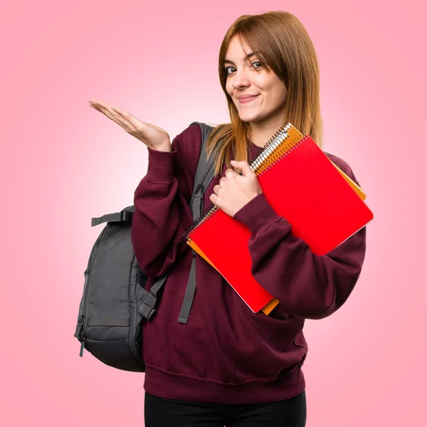 Estudiante mujer presentando algo sobre fondo colorido — Foto de Stock