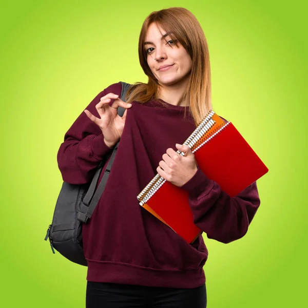 Studerande kvinna stolt över sig själv på färgstarka bakgrund — Stockfoto