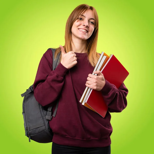 Öğrenci kadın ile renkli arka plan üzerinde başparmak