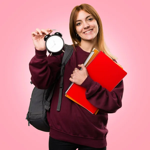Student-kvinna som håller vintage klocka på färgstarka bakgrund — Stockfoto