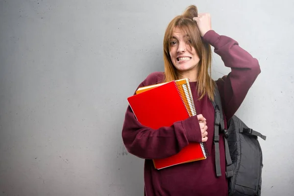 Mujer estudiante frustrada sobre fondo gris —  Fotos de Stock