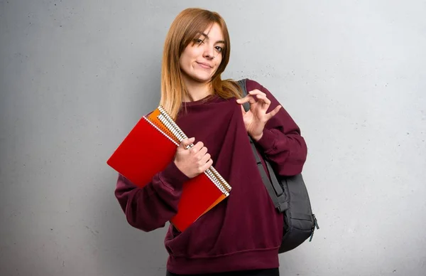 Student woman proud of herself on grey background