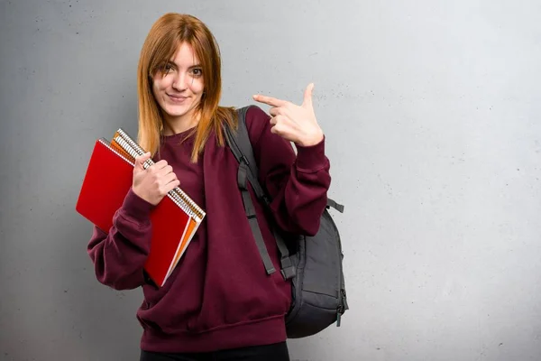 Student woman proud of herself on grey background