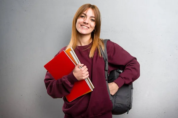 Mulher estudante feliz em fundo cinza — Fotografia de Stock