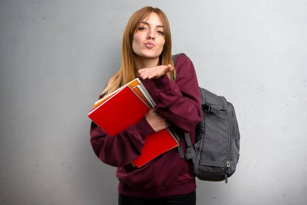 学生女人在灰色的背景上发送一个吻 — 图库照片