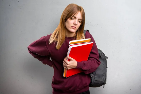 Student woman with back pain on grey background