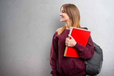 Öğrenci kadın gri arka plan üzerinde yanal arıyor