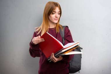 Öğrenci kadın gri arka plan üzerinde kitap okuma