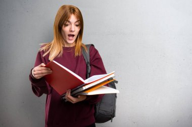 Öğrenci kadın gri arka plan üzerinde kitap okuma