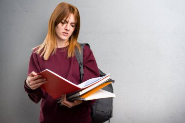 Öğrenci kadın gri arka plan üzerinde kitap okuma