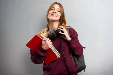 Öğrenci kadın müzik dinleme gri arka plan üzerinde