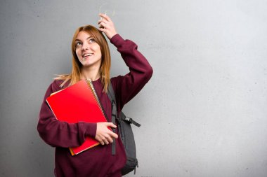 Bir ampul gri arka plan üzerinde tutan öğrenci kadın