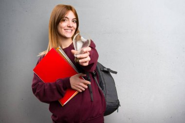 Bir ampul gri arka plan üzerinde tutan öğrenci kadın