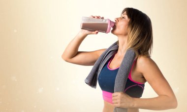 Sporcu kadın koyu sarı arka plan üzerinde spor içki içme