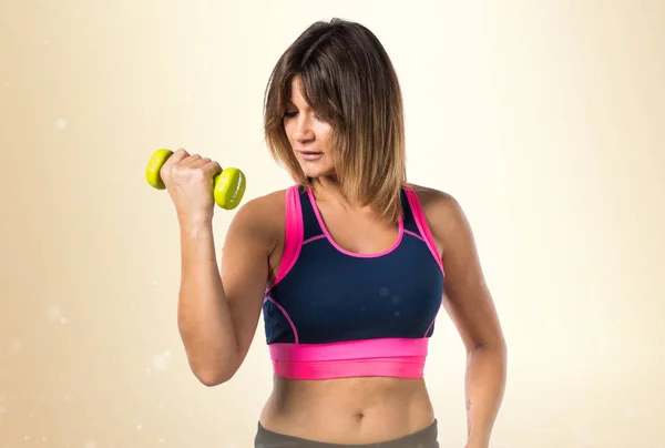 黄土色の背景に重量挙げを作るスポーツ女性 — ストック写真