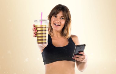 Spor kadın ile onun hareket eden ve ona spor içki okra backgro üzerinde