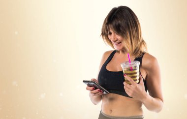 Spor kadın ile onun hareket eden ve ona spor içki okra backgro üzerinde