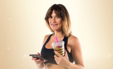 Spor kadın ile onun hareket eden ve ona spor içki okra backgro üzerinde