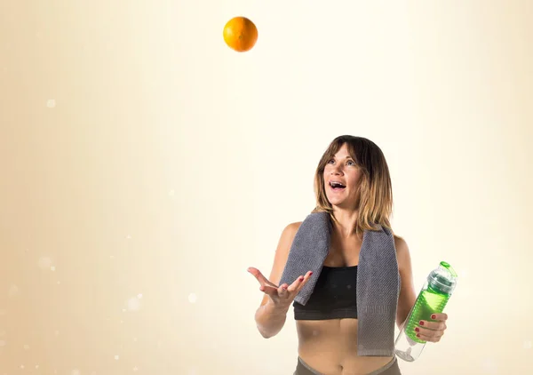 Sport donna giocando con un arancione su sfondo ocra — Foto Stock