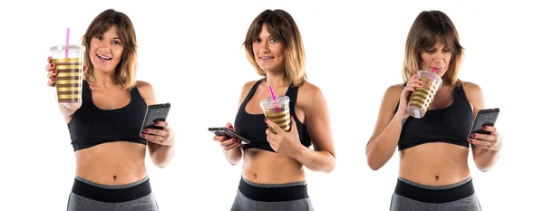 Sport woman with her mobile and her sport drink — Stock Photo, Image