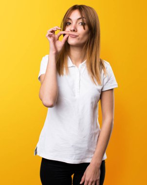 Güzel genç kız yapma sessizlik jest Sarı zemin üzerine