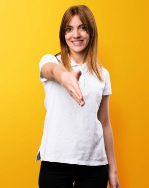 Güzel genç kız sarı arka plan üzerinde anlaşma