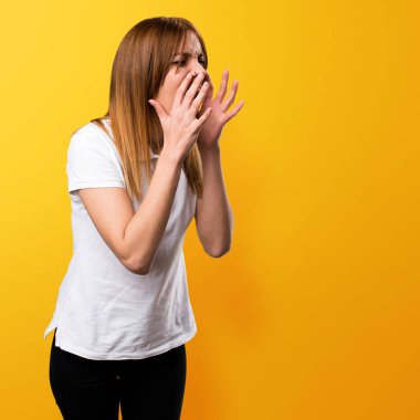 Güzel genç kız sarı zemin üzerine bağırarak