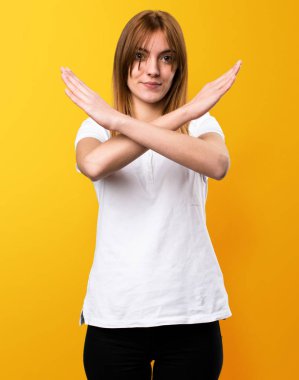 Güzel genç kız sarı arka plan üzerinde hiçbir hareketi yapma