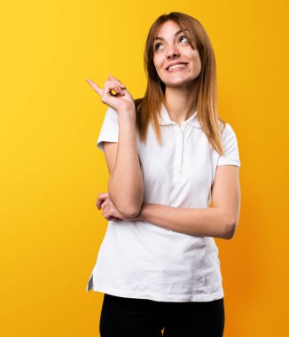 Güzel genç kız sarı arka plan üzerinde düşünme