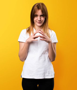 Güzel genç kız sarı arka plan üzerinde düşünme