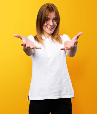 Bir şey üzerinde sarı arka plan sunulması güzel genç kız