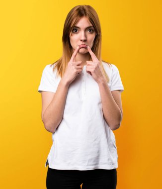 Sarı arka plan üzerinde üzgün güzel genç kız