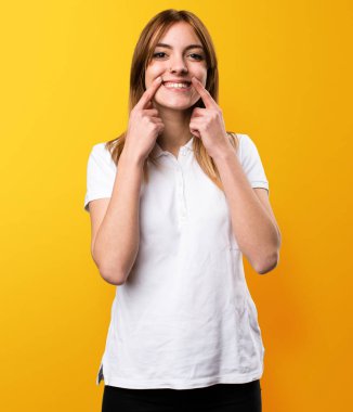 Sarı arka plan üzerinde mutlu güzel genç kız