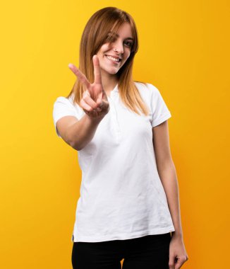 Güzel genç kız yapma zafer jest Sarı zemin üzerine