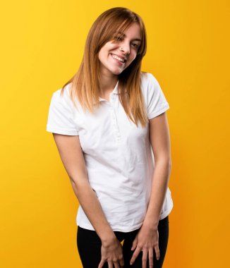 Güzel genç kız sarı arka plan üzerinde göz kırpıyor