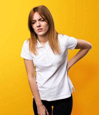 Güzel genç kız sarı zemin üzerine sırt ağrısı ile