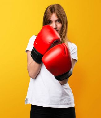 Güzel genç kız sarı zemin üzerine boks eldivenli