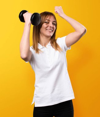 Mutlu güzel genç kız halter sarı backgr yapma