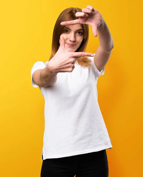 Schönes junges Mädchen, das sich mit ihren Fingern auf den gelben Rücken konzentriert — Stockfoto