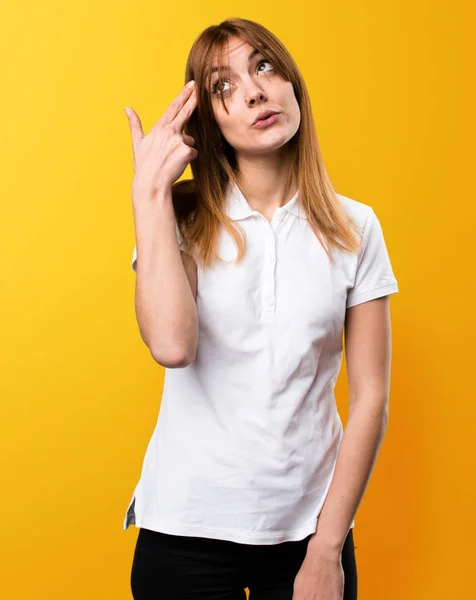 Menina bonita fazendo gesto de suicídio no fundo amarelo — Fotografia de Stock