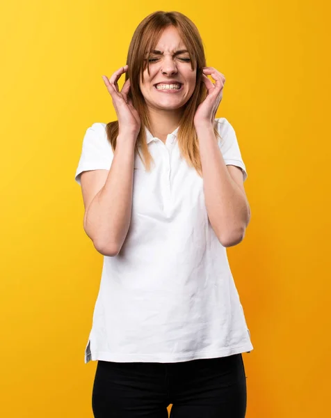 Bella ragazza che si copre le orecchie su sfondo giallo — Foto Stock