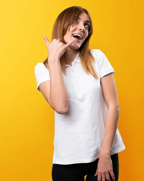 Schönes junges Mädchen macht Handygeste auf gelbem Hintergrund — Stockfoto